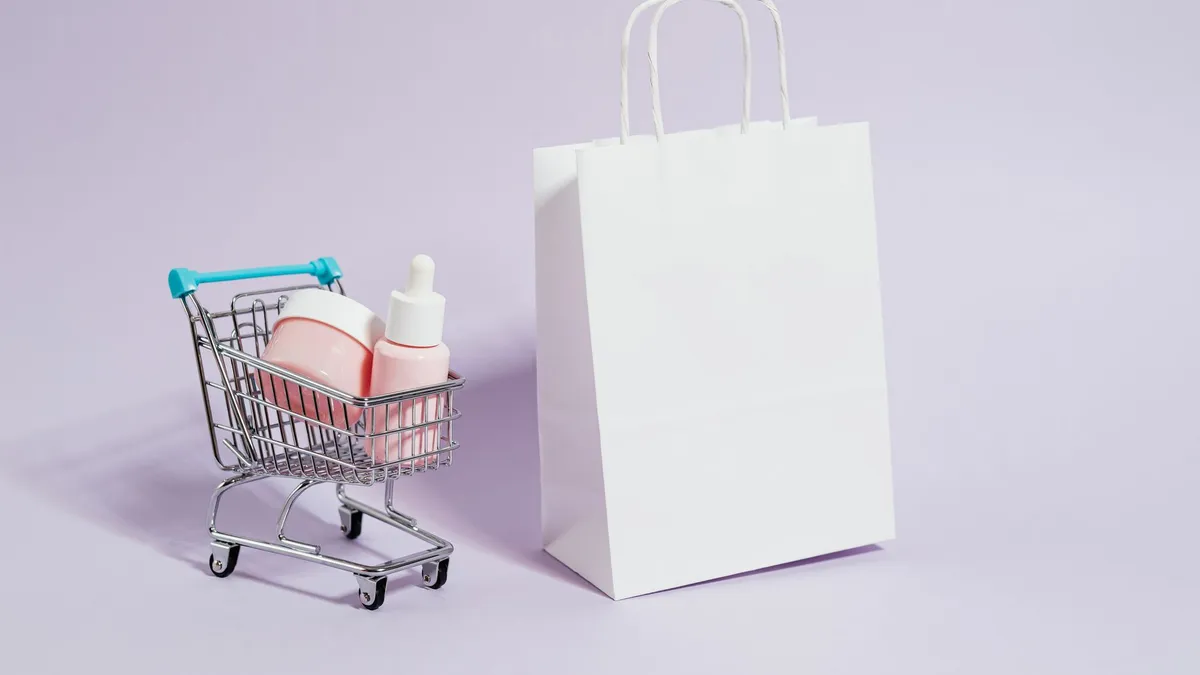 Xe đẩy mua hàng mini cạnh túi giấy và sản phẩm