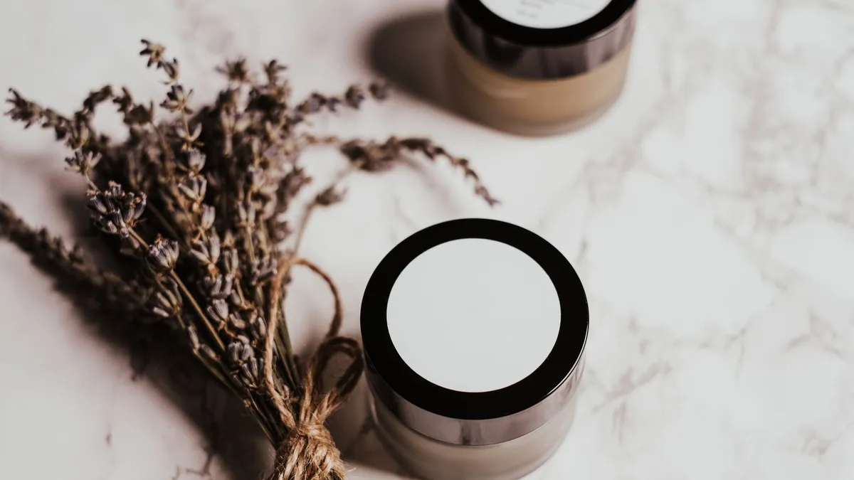 Hũ kem và nhành lavender khô trên mặt đá cẩm thạch