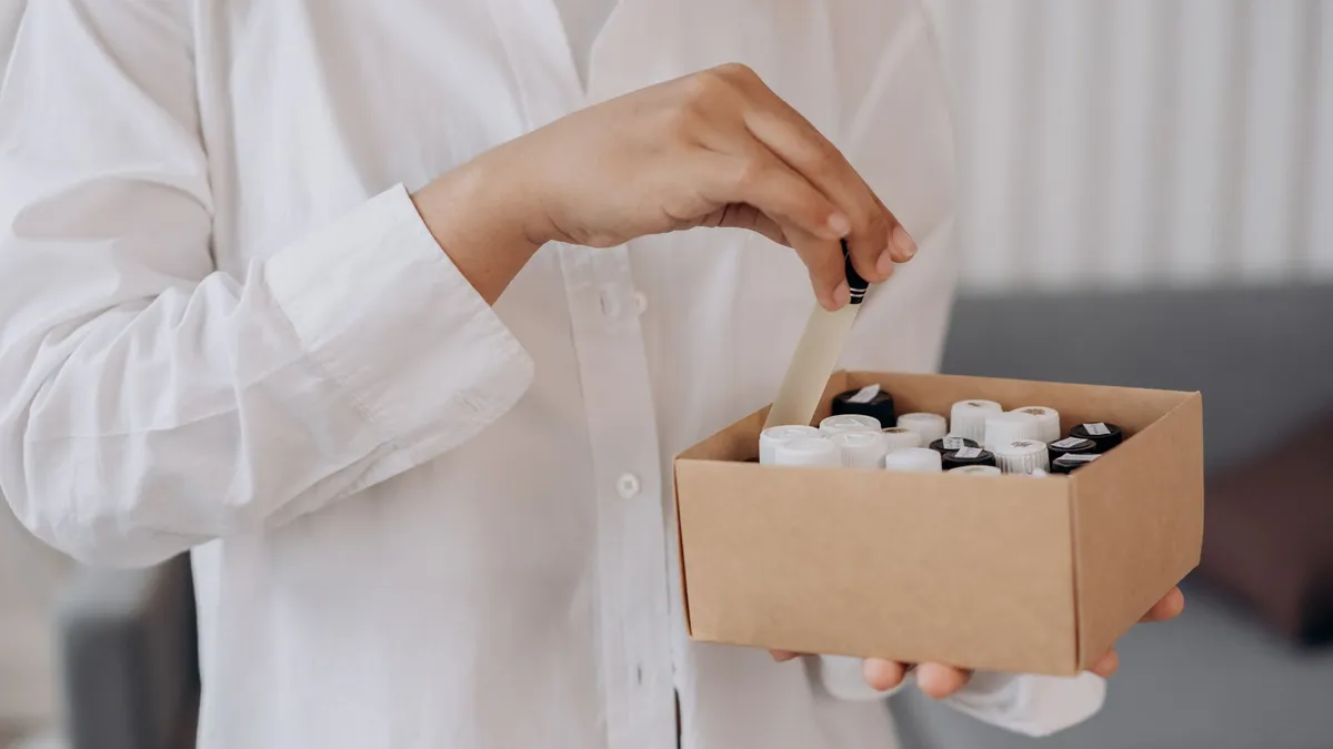 Tay lấy chai từ thùng carton