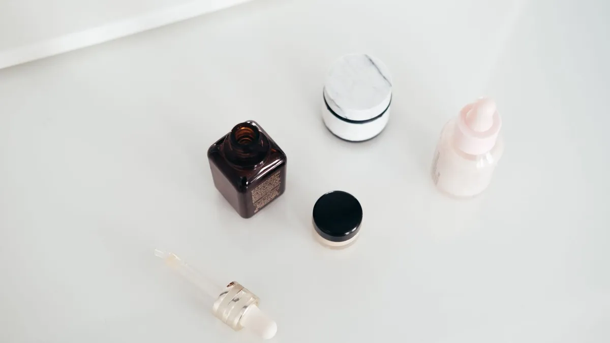 Chai và hũ mỹ phẩm màu trắng, nâu trên nền trắng