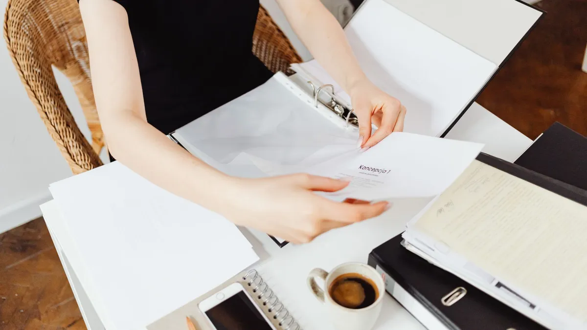 Tay lật giấy tờ trên bàn làm việc