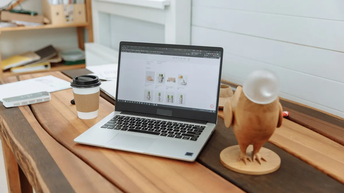 Laptop đang mở trang web bán hàng đặt trên bàn gỗ